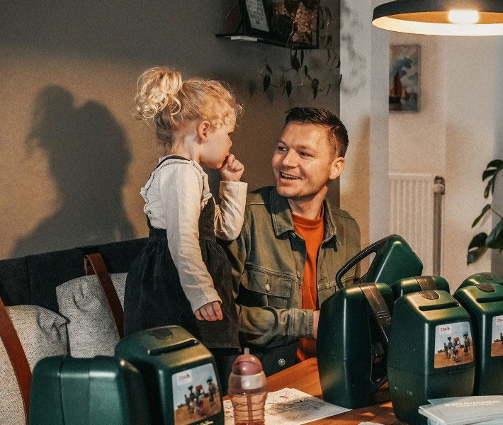 Lachend gezin aan eettafel met collectebussen