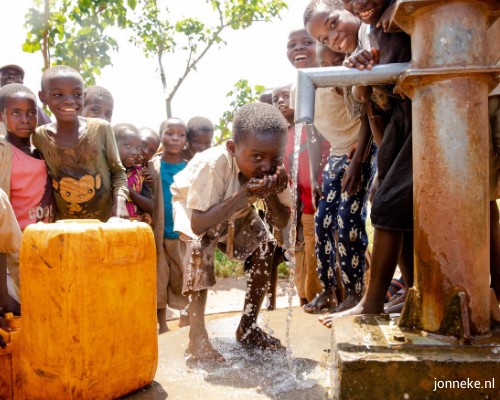 Kind drinkt aan waterpomp in Burundi